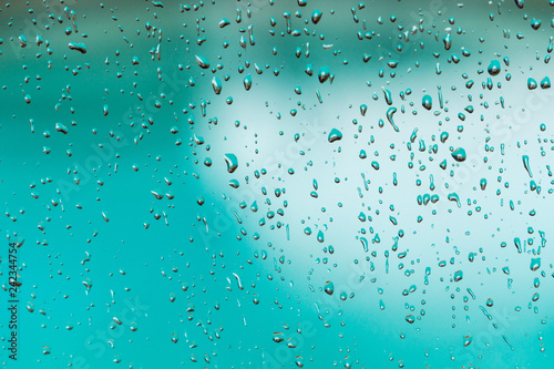 Rain drops on the window  blurred blue pool water in the background