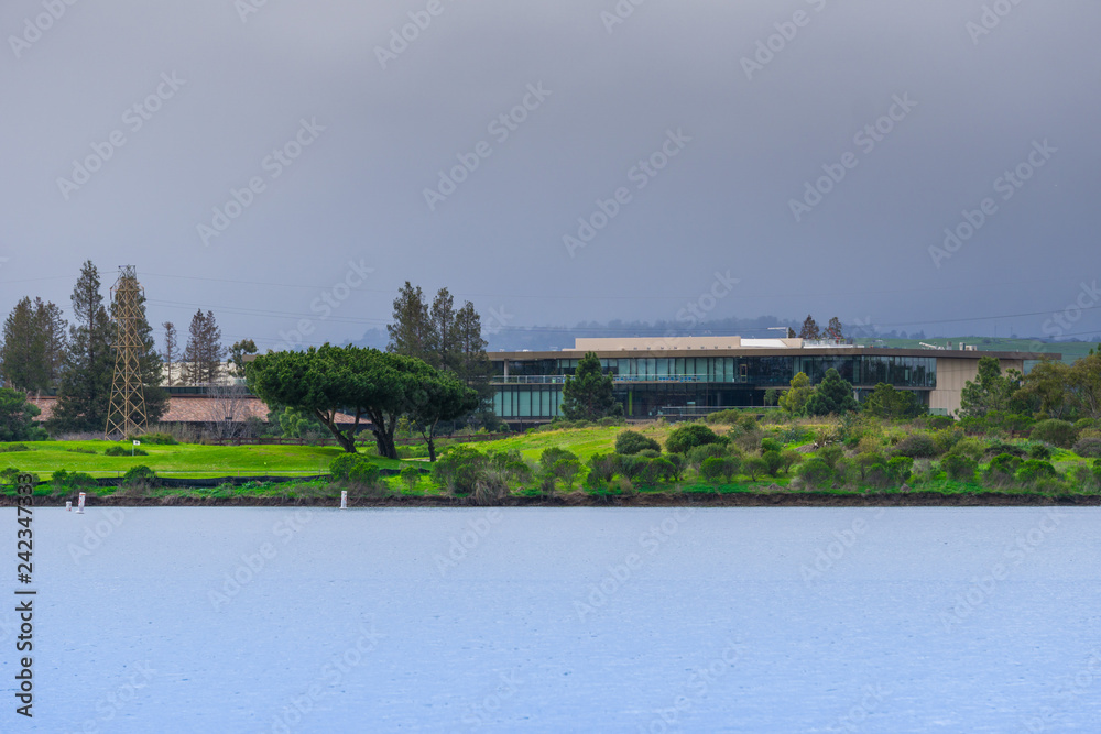 Office building on a lake shoreline on a cloudy day, Silicon Valley, Mountain View, California