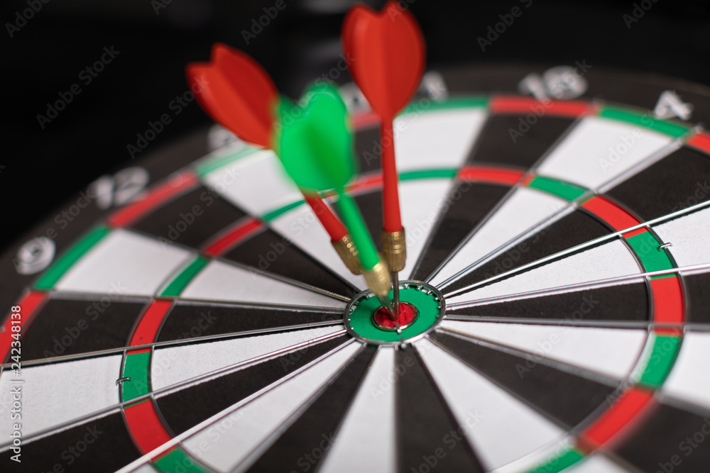 Three Darts hit red target close-up Three Darts hit red target close-up