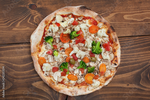 Fresh italian vegetariana pizza on wooden background, top view
