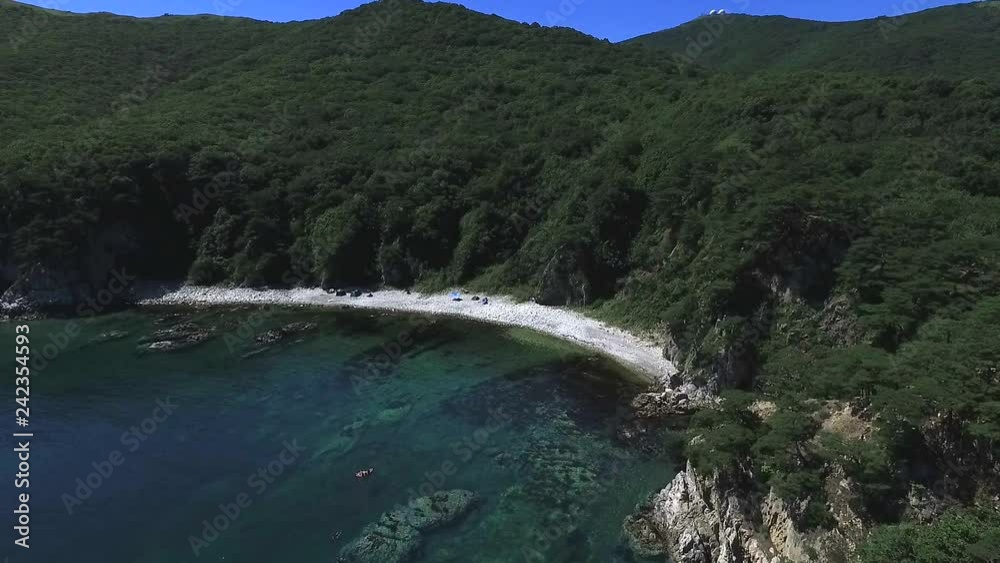 Aerial shot of exotic tropical ocean coast on sunny day. Tropical blue ocean, green trees mountains, cliffs, blue skies with clouds. Aerial shot of exotic tropical ocean coast on sunny day. Tropical blue ocean, green trees mountains, cliffs, blue skies with clouds.