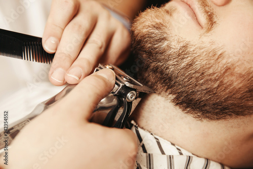 Bearded hipster trim beard in men hair salon photo