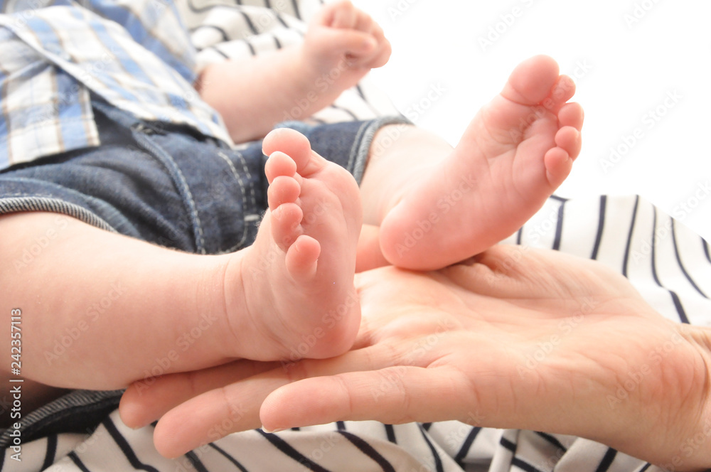 mother holding newborn baby foot with white backgound