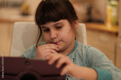 Portrait of caucasian girl watching at her tablet, device