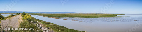 Photo Panoramic view of levee going through the marsh and ponds in south San Francisco