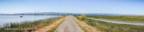 Panoramic view of levee going through the marsh and ponds in south San Francisco bay  California