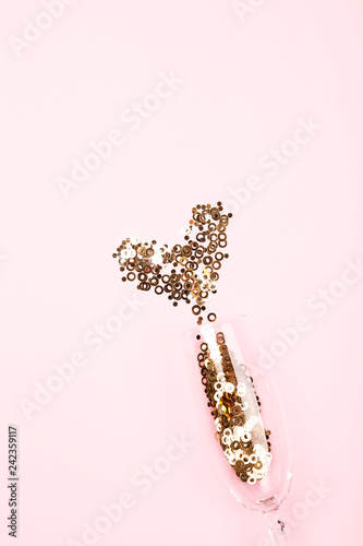 Holiday background with confetti and glass of champagne.