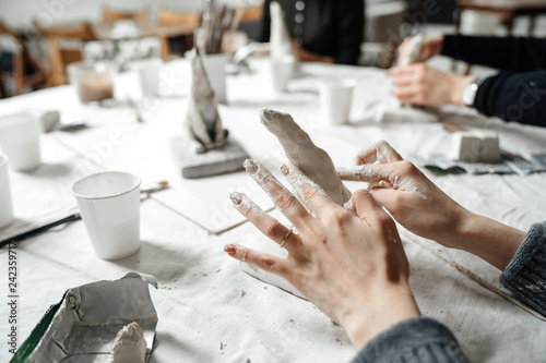 Female hands elegantly shape a small plaster sculpture at a master class. Creativity and hobby.