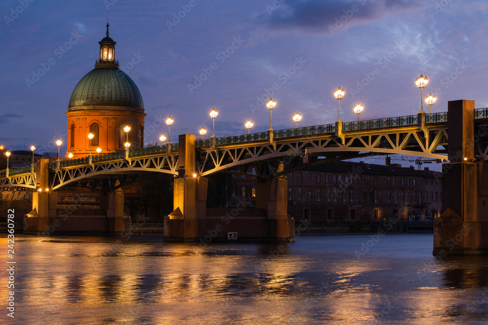 Atardecer sobre el río Garona. Puente iluminado en la ciudad de Toulouse