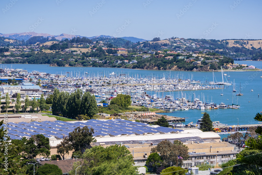 Aerial view of the bay and marina from the hills of Sausalito; solar panels installed on the rooftop of a building, San Francisco bay area, California
