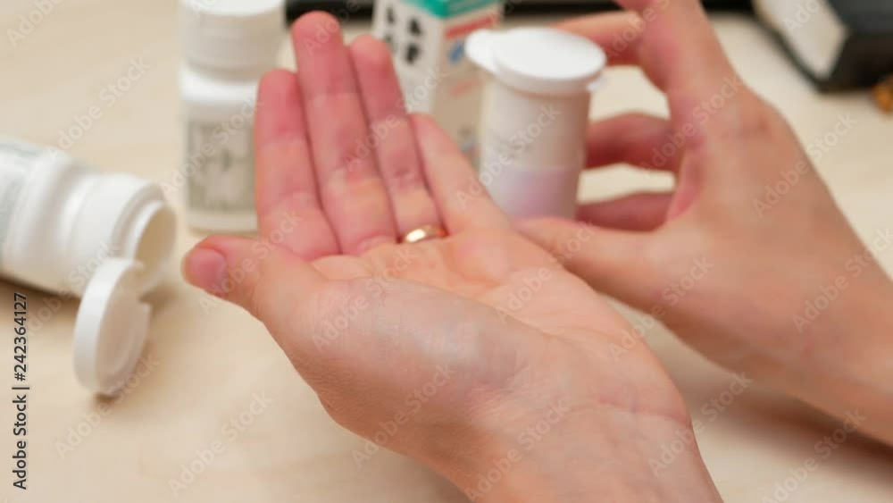 Woman pouring bunch of prescription yellow opiate pills into hand Woman pouring bunch of prescription yellow opiate pills into hand