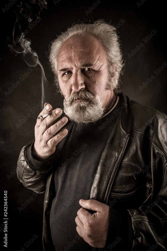Obraz premium Grumpy senior man smoking