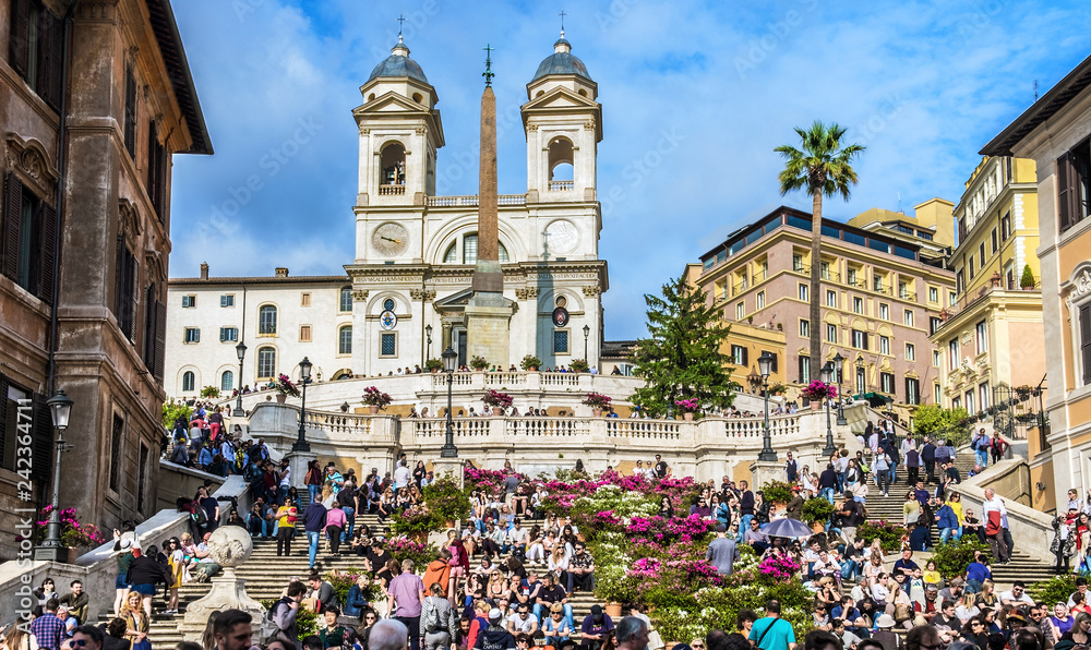 Fototapeta premium Piazza di Spagna, widok z Via Condotti. Wiele osób jest na Schodach Hiszpańskich w pobliżu kościoła Świętej Trójcy Gór i Obelisku Sallustiano. Rzym.