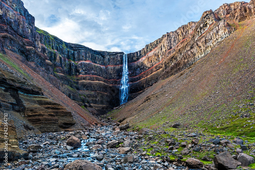 View at Hengifoss waterfall and basaltic strata with thin, red and yellow layers of clay photo