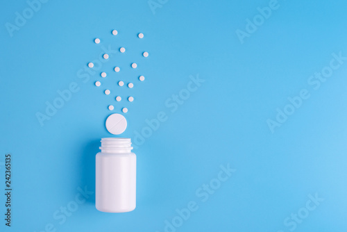Tablets and bottle on blue background