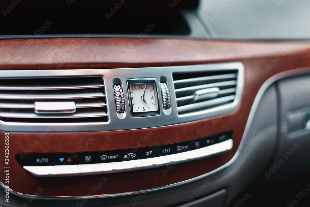 Clock in luxury car dashboard. Watch in transportation. Air conditioner ventilation in car.