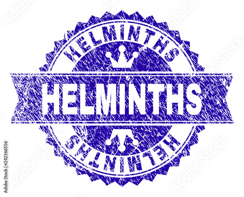 HELMINTHS rosette stamp imprint with grunge style. Designed with round rosette, ribbon and small crowns. Blue vector rubber watermark of HELMINTHS title with dust style.