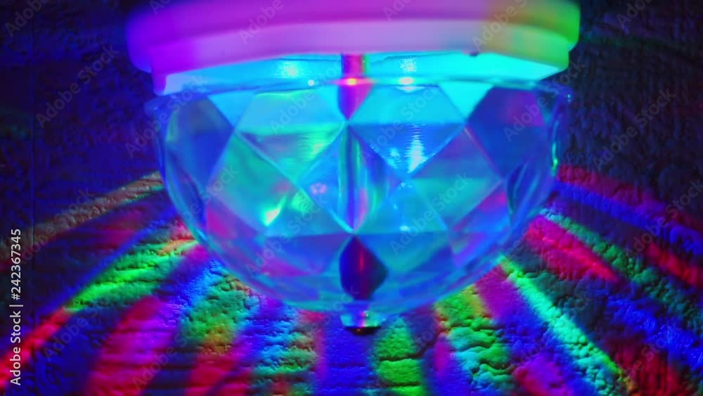 night lamp rotates and shines with multicolored rays that leave reflections on the surface.abstract festive background with multicolored rays night lamp rotates and shines with multicolored rays that leave reflections on the surface.abstract festive background with multicolored rays