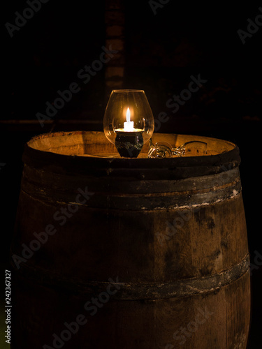 Small candlelight in a glass in a almost forgotten wine cellar