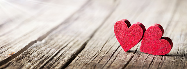 Two Wooden Hearts On Rustic Table With Sunlight
