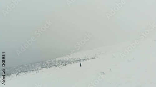 Wallpaper Mural Mountaineer backpacker walking aerial view. Journey in the mountains in winter. Extreme vacation in nature. Travel alone extreme weather concept. Drone view person hiking snow mountains. Torontodigital.ca