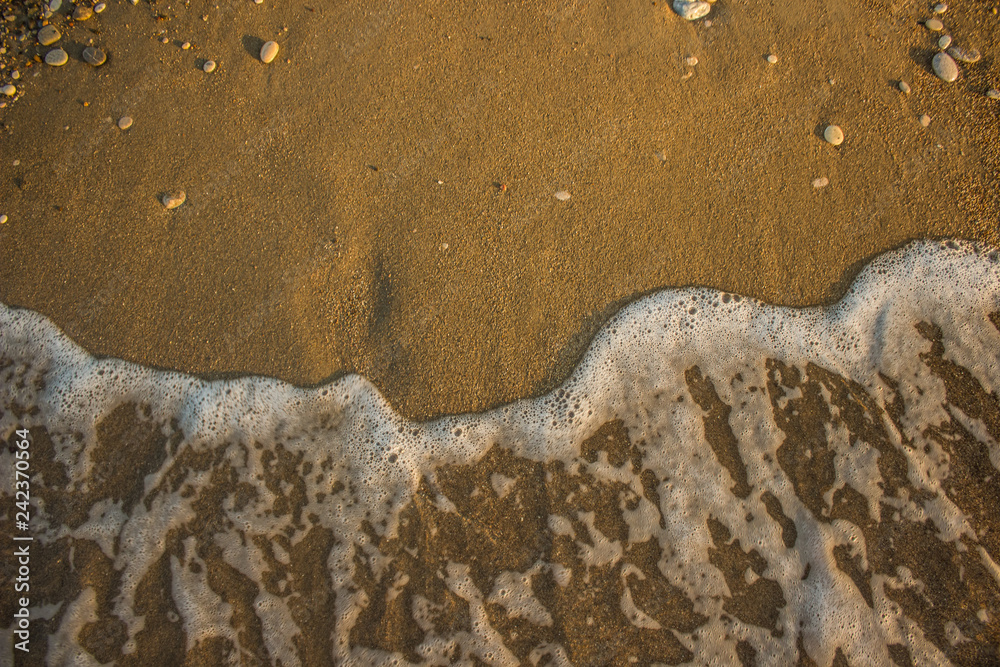 Obraz premium aerial wallpaper background concept photography of washed away human foot prints from sand shoreline surface by fuzzy waves, sea and summer vacation theme with empty copy space for your text