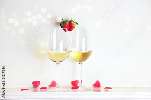 Two glasses of white wine with strawberry heart shape. Valentine's day 