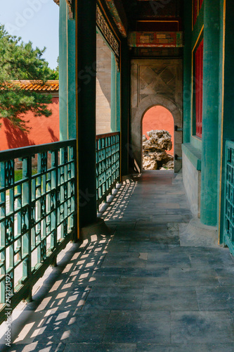 Covered pathway leading to an arched door with rock, in Forbidden City, Bejing, China