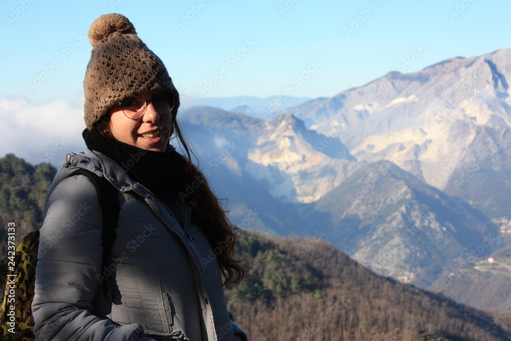 a young woman makes trekking on a mountain in a winter day