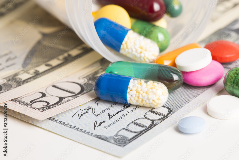 Various pills on American dollars banknotes, cost of medicine concept Various pills on American dollars banknotes, cost of medicine concept