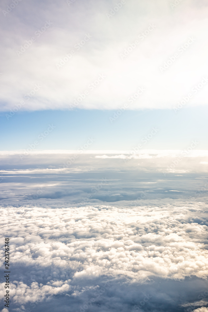 Obraz premium Isolated sky cloudscape with fluffy clouds on horizon and bright soft sunny sunlight aerial high angle vertical view of from airplane
