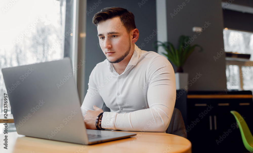 Young man using laptop in a cafe shop. Young man using laptop in a cafe shop.