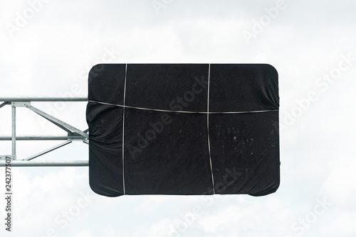 Miami, USA Road street highway black construction cover on sign in Florida tied with string isolated against cloudy white sky photo