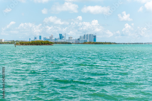 Sunny day in Bal Harbour, Miami Florida with light green turquoise ocean Biscayne Bay Intracoastal water and cityscape skyline of Sunny Isles Beach photo