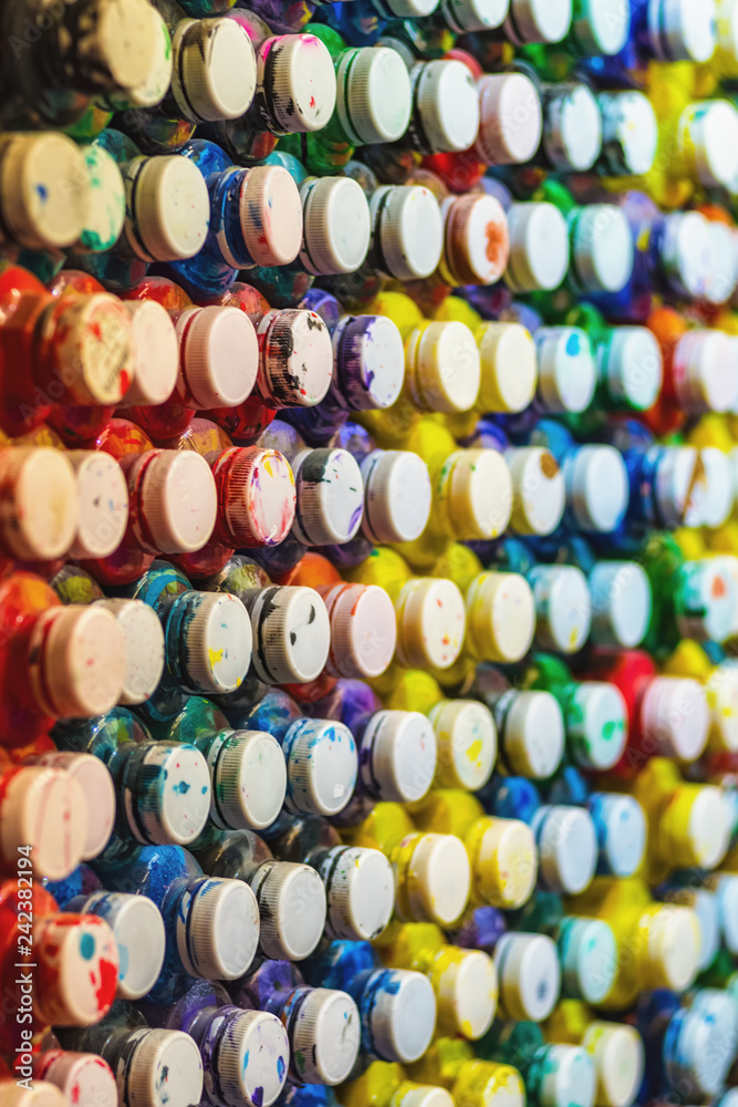 many cans of paint with lids lined in a row