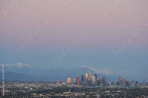 Los Angeles skyline at dusk with Mount San Antonio in the background.