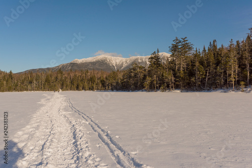 the sun stars to set along a well worn path across a frozen lake