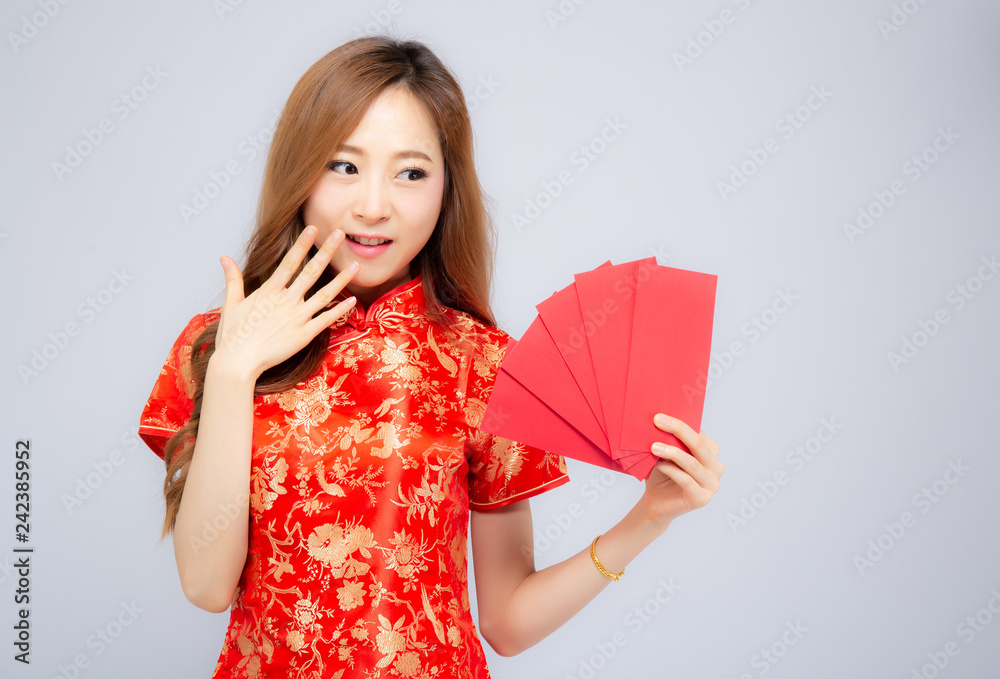 Beautiful portrait young asian woman cheongsam dress smiling holding red envelope on white background, girl celebrate with exciting, happy Chinese New Year, holiday concept. Beautiful portrait young asian woman cheongsam dress smiling holding red envelope on white background, girl celebrate with exciting, happy Chinese New Year, holiday concept.