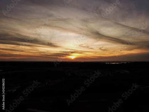 sunset behind clouds with city skyline