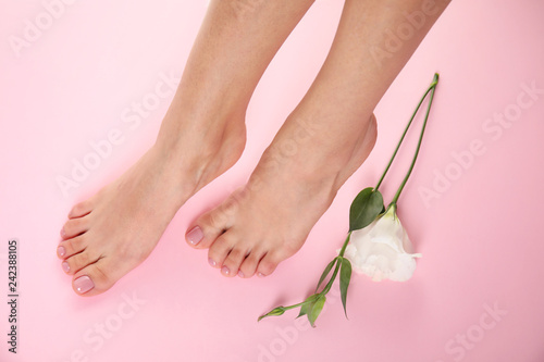Fototapeta Naklejka Na Ścianę i Meble -  Woman with smooth feet and flower on color background, closeup. Spa treatment