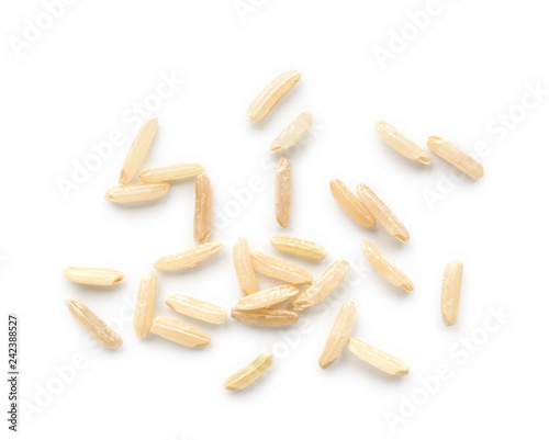 Scattered grains of brown rice on white background, top view