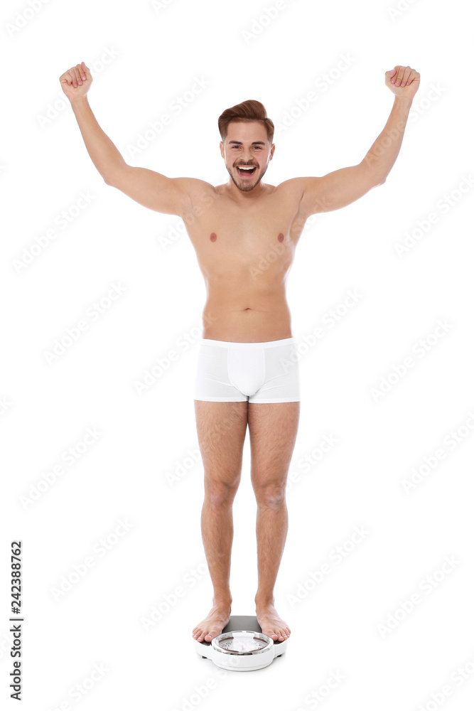 Fit man standing on bathroom scale against white background. Weight loss Fit man standing on bathroom scale against white background. Weight loss