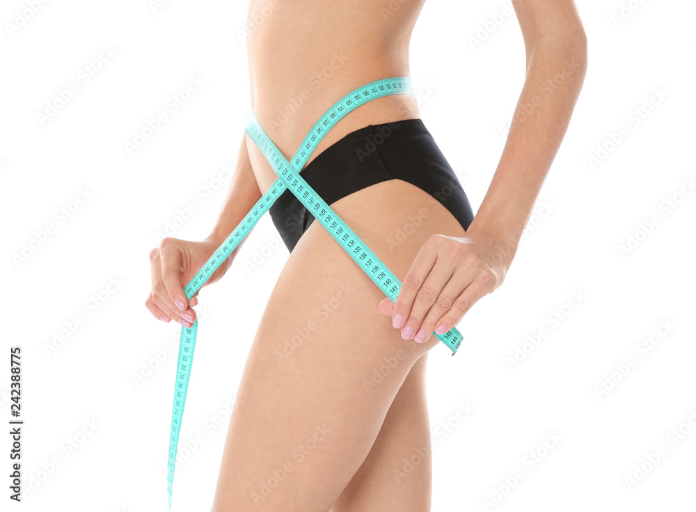 Slim woman measuring her waist on white background, closeup. Weight loss