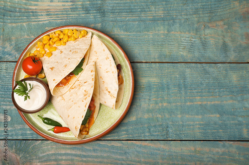 Plate of tortillas with chili con carne on wooden background, top view. Space for text