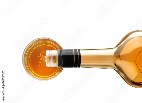 Pouring expensive whiskey into glass on white background, top view