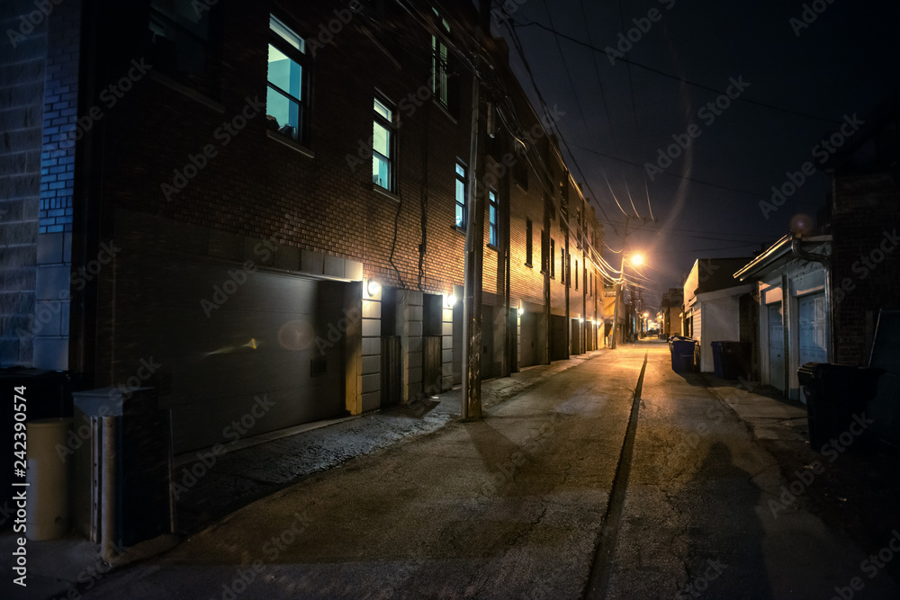 Shadow of a person in a dark scary alley at night