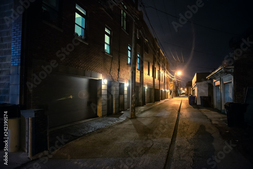 Shadow of a person in a dark scary alley at night