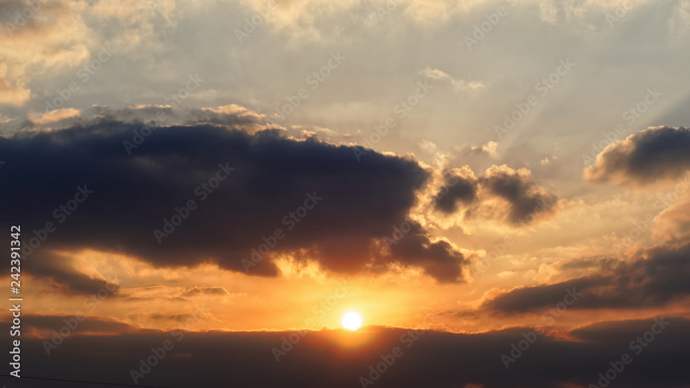 Bright big sun on the sky with yellow orange gradient colors, beautiful sunset cloudy sky.