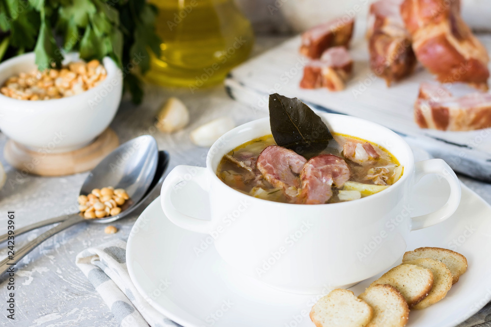 Thick pea soup with smoked meats in a white plate Thick pea soup with smoked meats in a white plate
