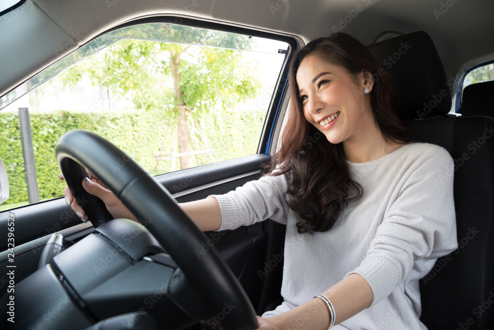 Asian women driving a car and smile happily with glad positive expression during the drive to travel journey, People enjoy laughing transport and relaxed happy woman on roadtrip vacation concept Asian women driving a car and smile happily with glad positive expression during the drive to travel journey, People enjoy laughing transport and relaxed happy woman on roadtrip vacation concept